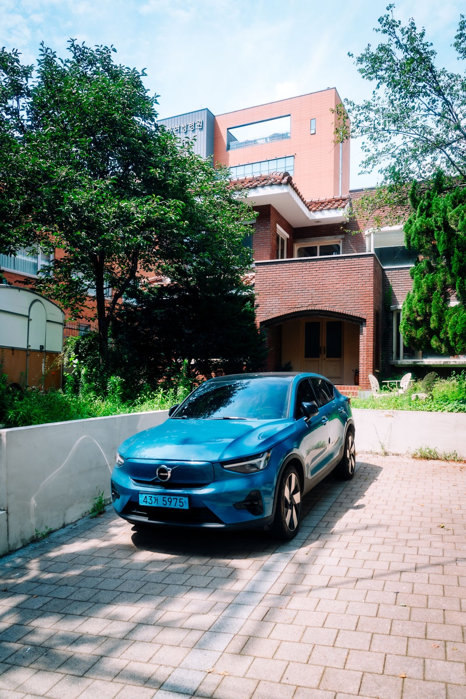 An EV parked in a driveway with a V2L adapter powering a home appliance during an outage