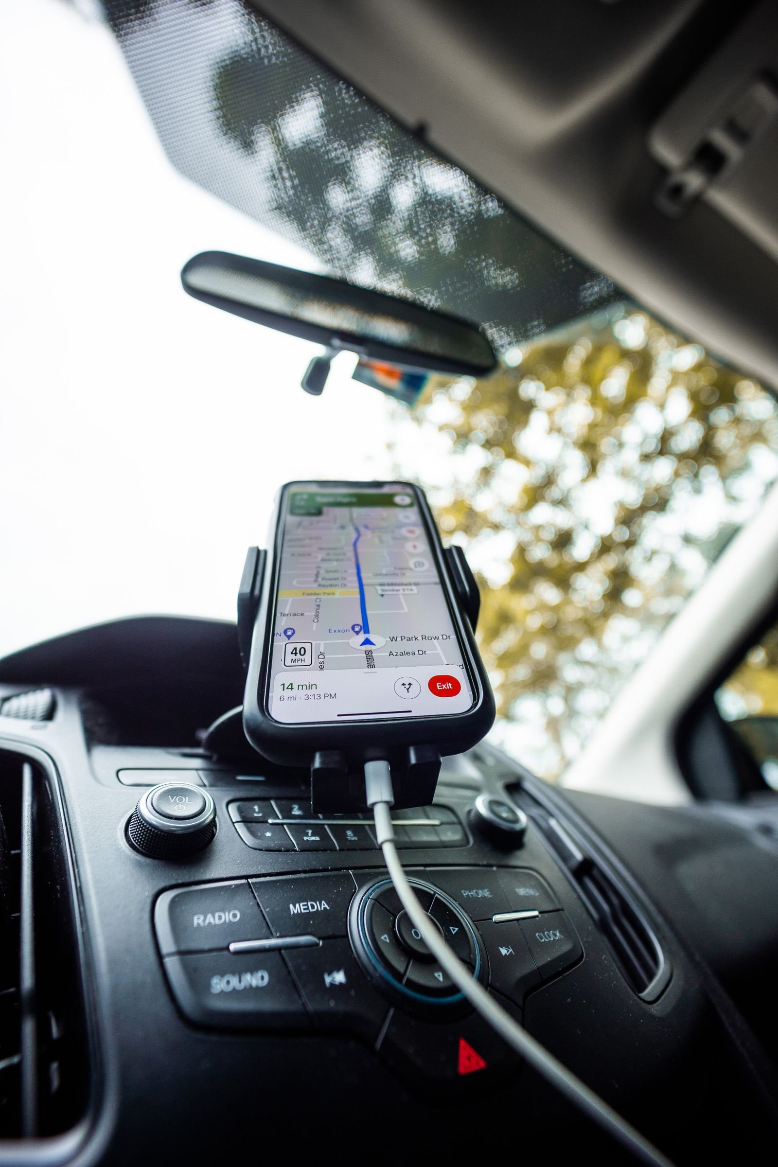 A route-planning app and PlugShare open on a phone mounted in an EV