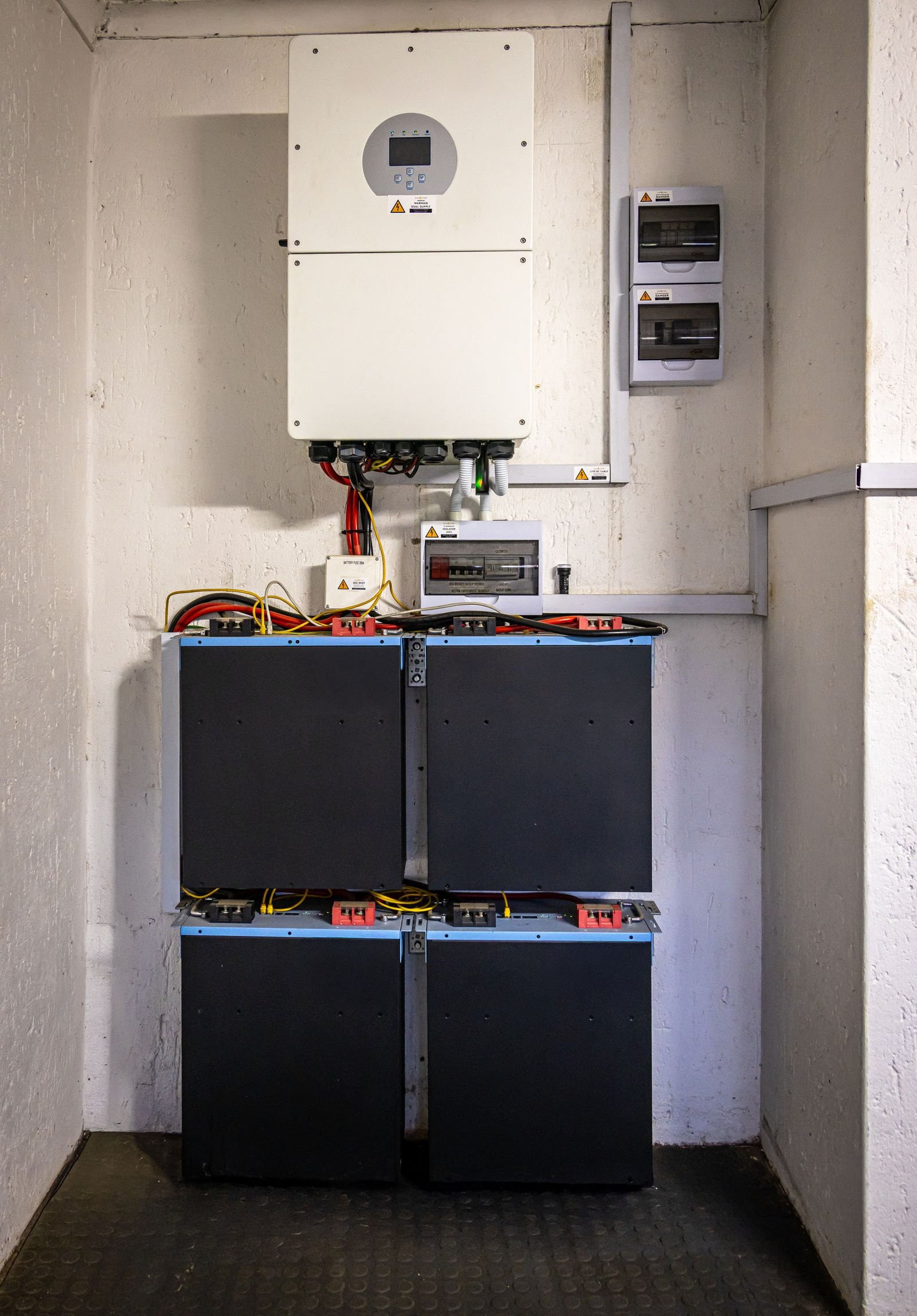 Home battery unit mounted on an exterior garage wall