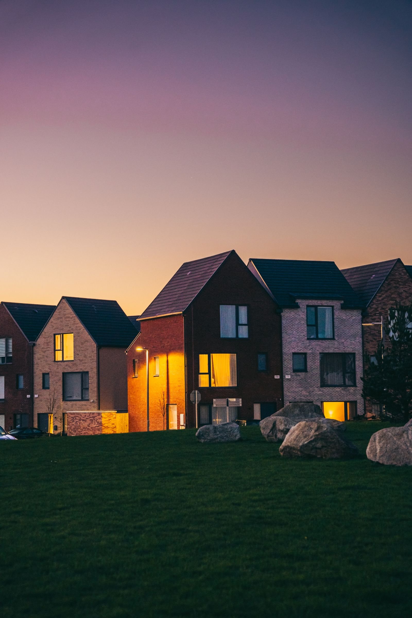A lit, cool home at dusk during a neighborhood power outage, powered by a solar and battery backup system