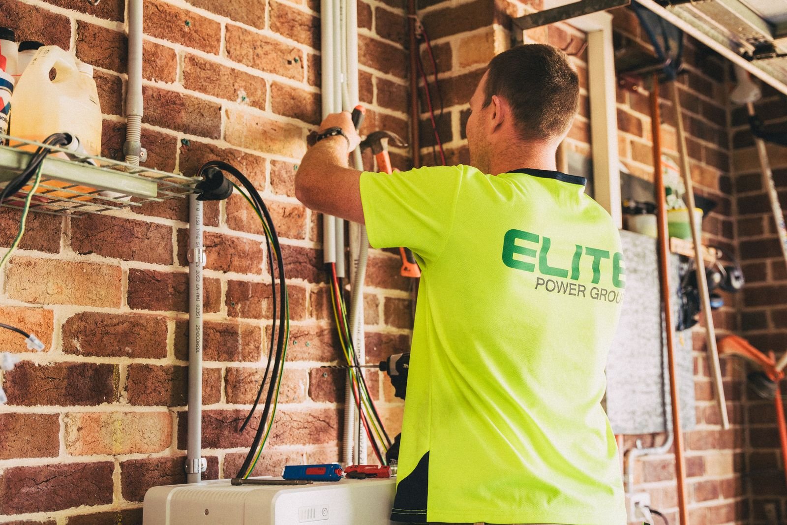 A factory Tesla Powerwall mounted on an exterior house wall for contrast