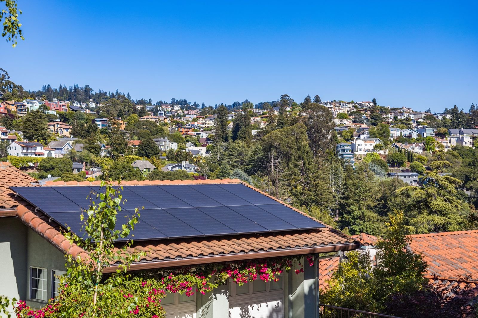 Rooftop solar panels on a suburban home in full afternoon sun