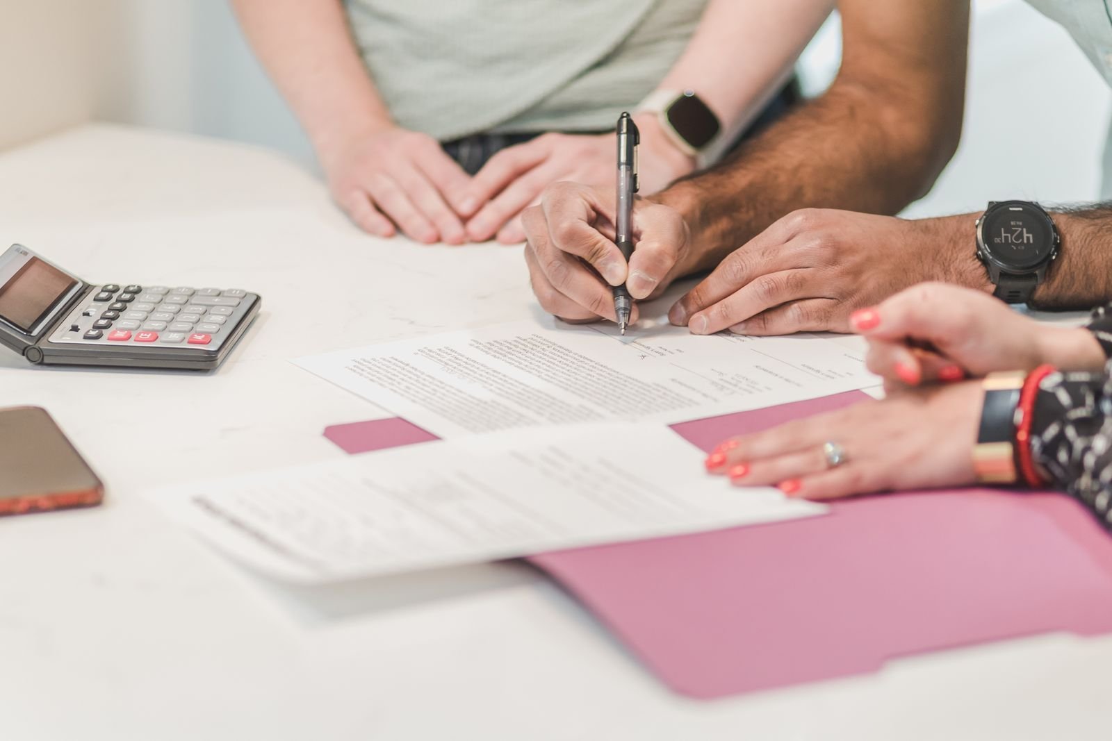 Homeowner reviewing solar financing paperwork with a calculator at a kitchen table