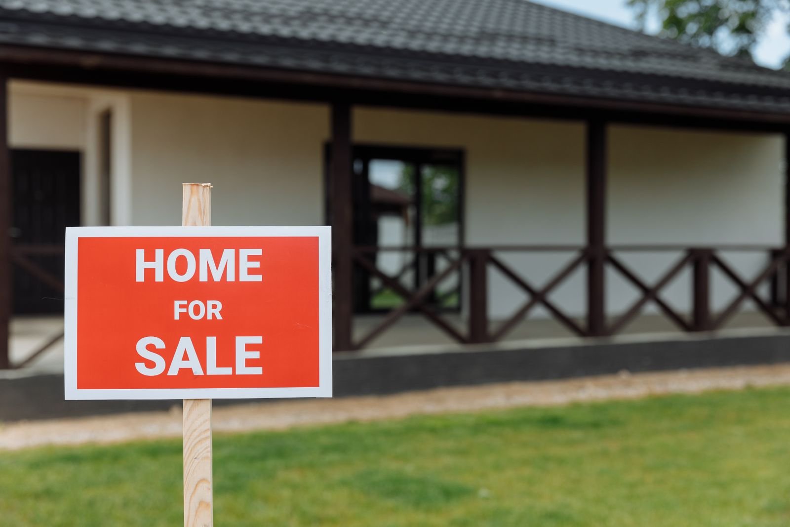 Suburban for-sale home with rooftop solar panels and an agent's sign in the yard