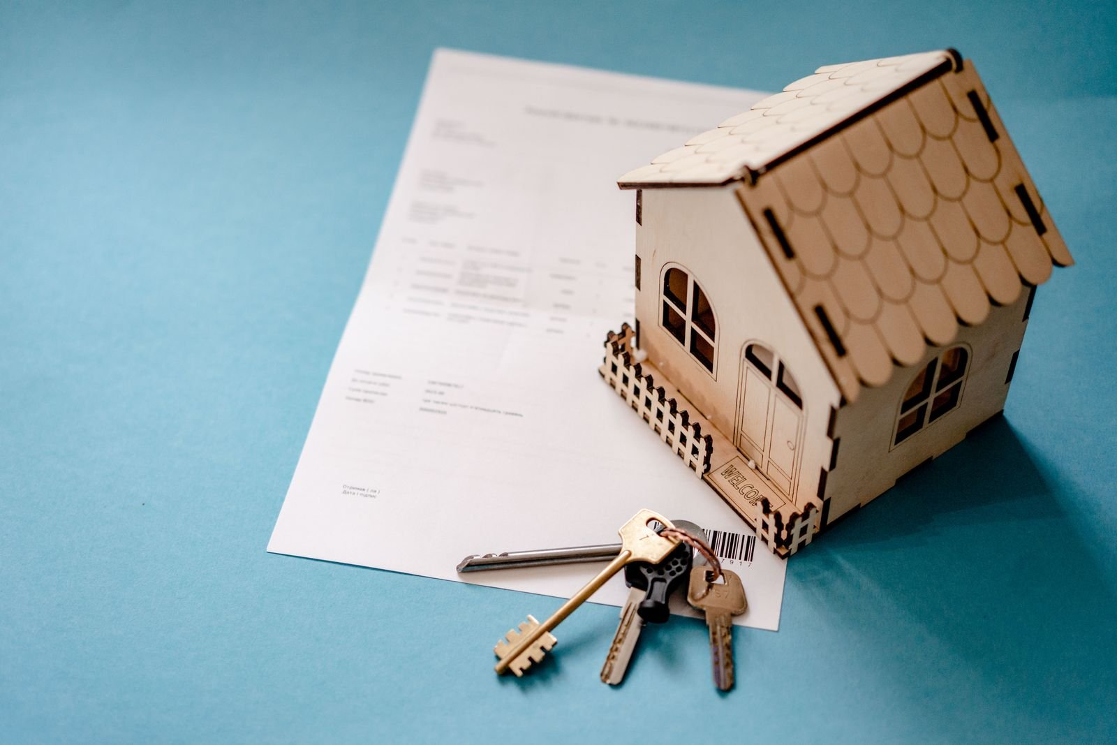 Closing paperwork and a title lien search open on a laptop at a kitchen table